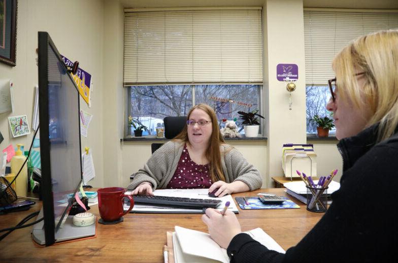 A Financial Aid counselor works with a student in an office